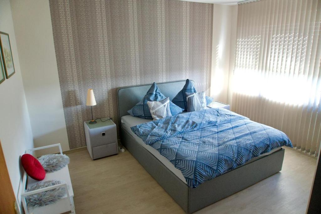a bedroom with a bed with a blue comforter at Ruhiges Apartment am Stadtrand in Kevelaer