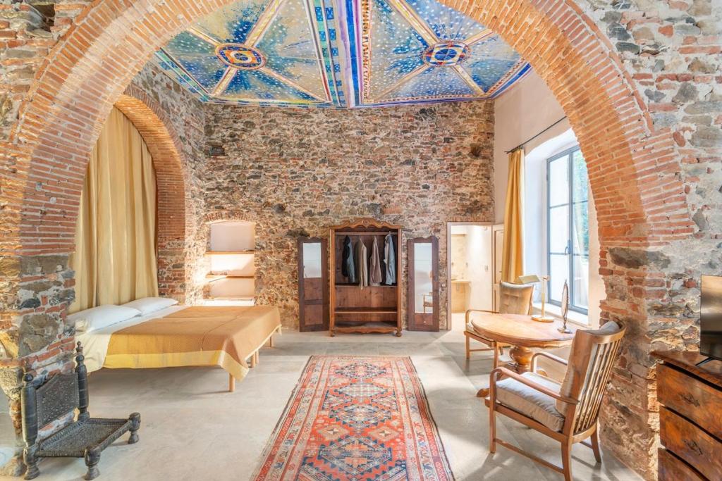 a bedroom with a bed and a brick wall at Garibaldi Art Apartment in Piombino