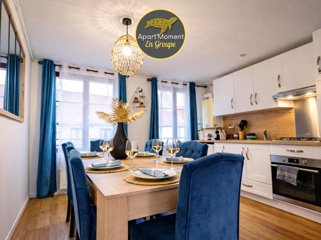 a kitchen and dining room with a wooden table and chairs at Le Spacieux à Saint-Omer - 2 chambres, centre et gare à pied, parking privé gratuit in Saint-Omer