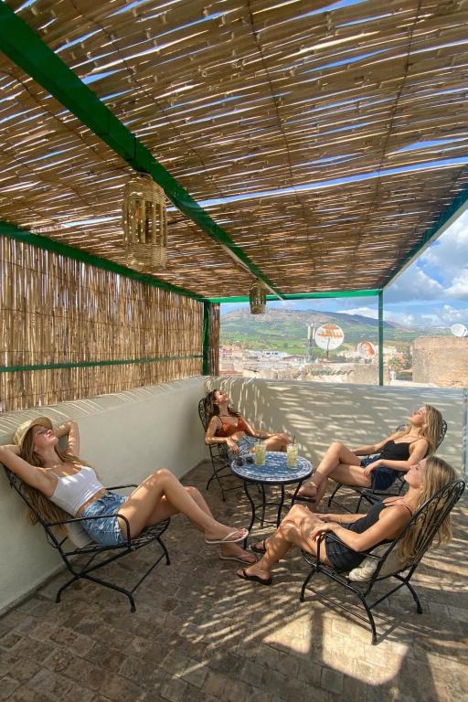 three women are sitting in chairs on a patio at Dar cheikh in Fez