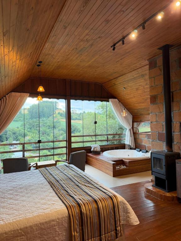 a bedroom with a bed and a tub in a room at Chalé Vicenza in Marques de Sousa