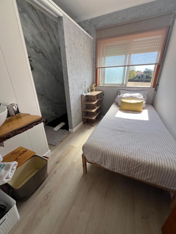 a small bedroom with a bed and a window at Grace House Quarto single privado in Belinho