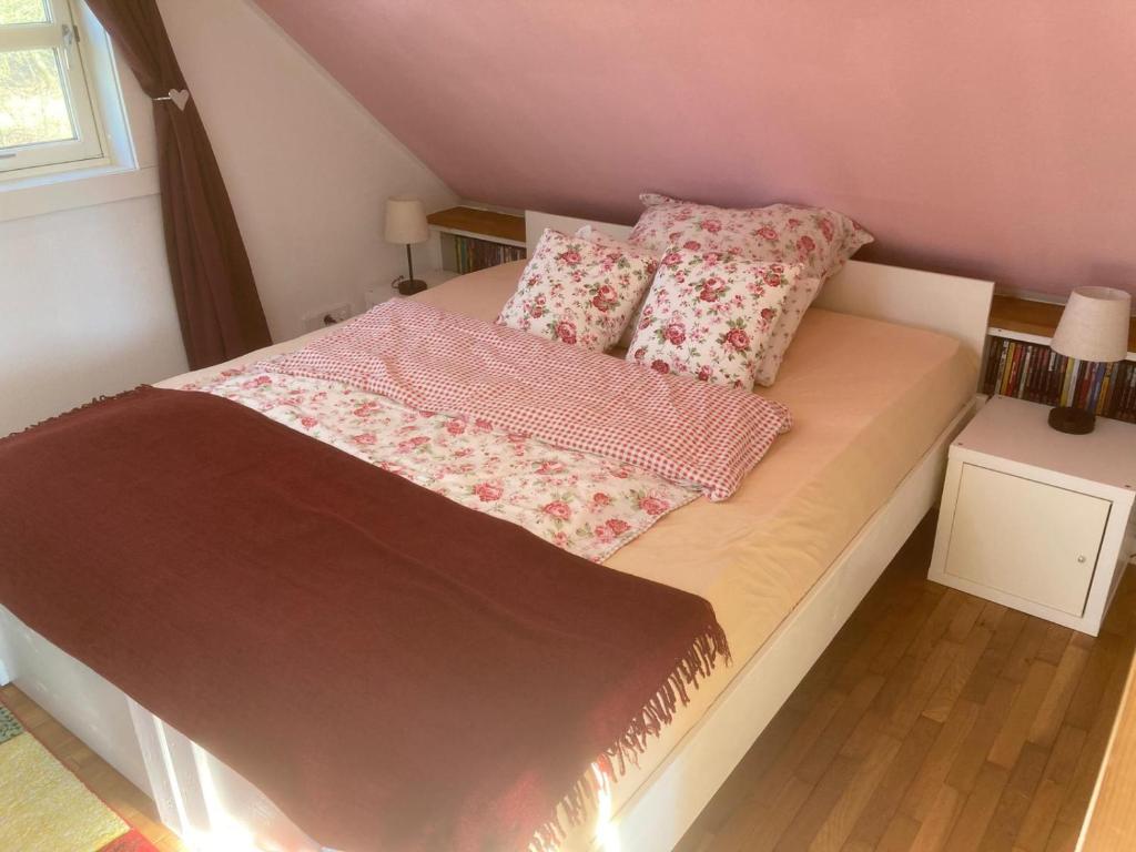 a bed with pink sheets and pillows on it at gemütliches Gästezimmer in Ostseenähe in Stubbendorf