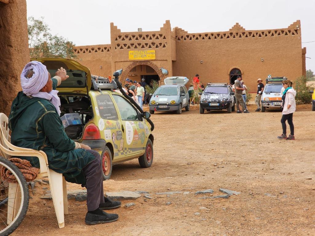 a woman sitting in a chair next to a small car at Hamada Kem-Kem Tafraoute in Tafraoute Sidi Ali
