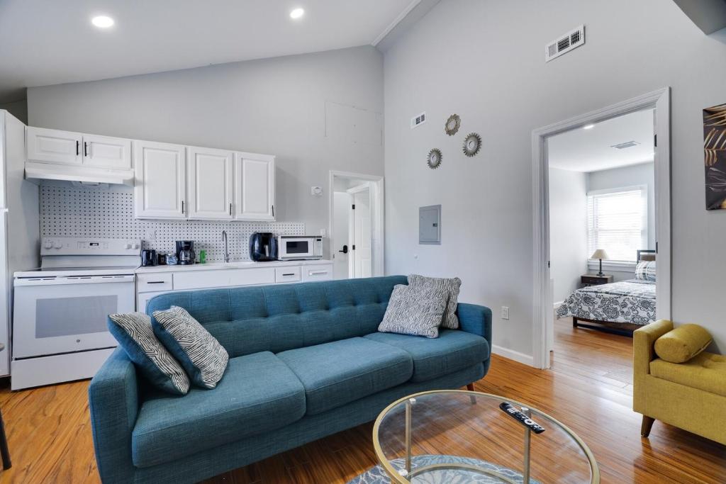 a living room with a blue couch and a kitchen at 2BR Apt Near EWR & NYC • Workspace + Parking in Newark