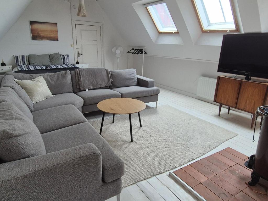 a living room with a couch and a tv at Solbacken in Bjärred
