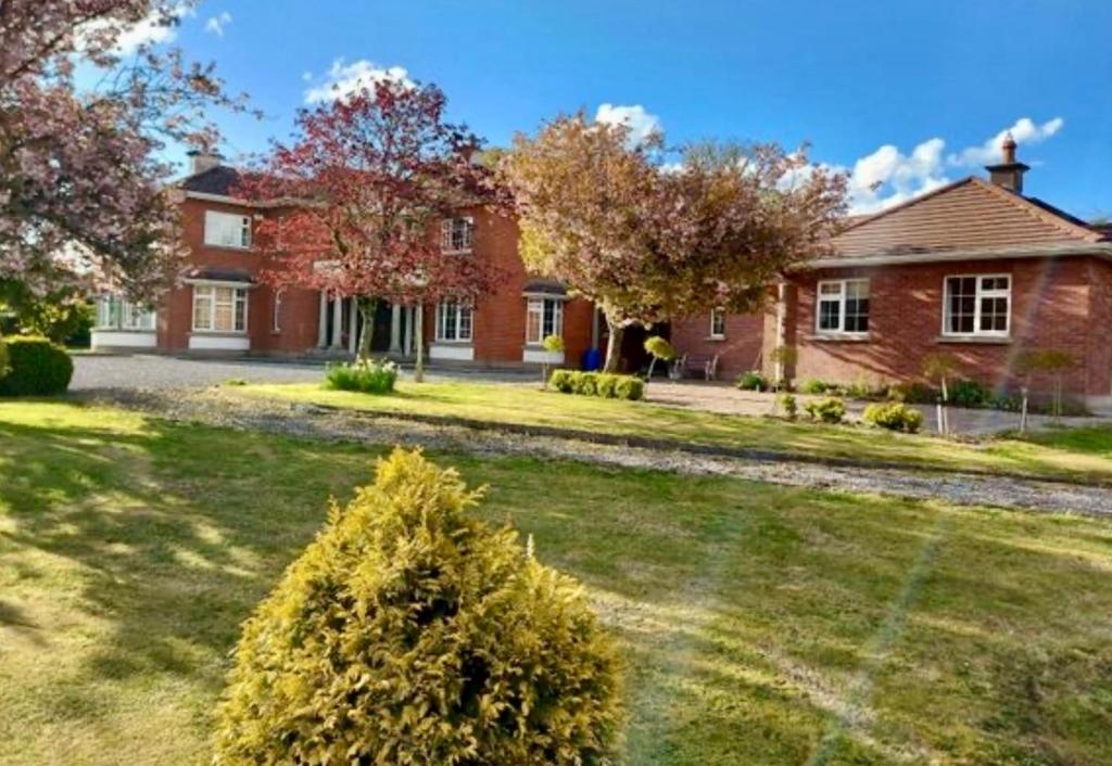 a brick house with a yard with a house at Whitaker Lodge in Swinford