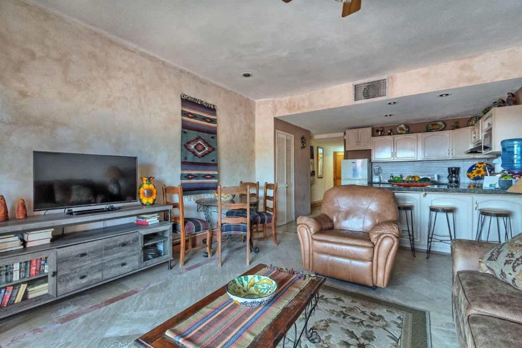 a living room with a television and a couch and a table at Unique Colorful Condo on 3rd Floor Pinacate 321 in Puerto Peñasco