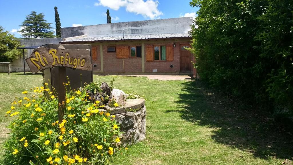 una casa con un cartel delante de un patio en Cabañas Mi Refugio en Villa Giardino