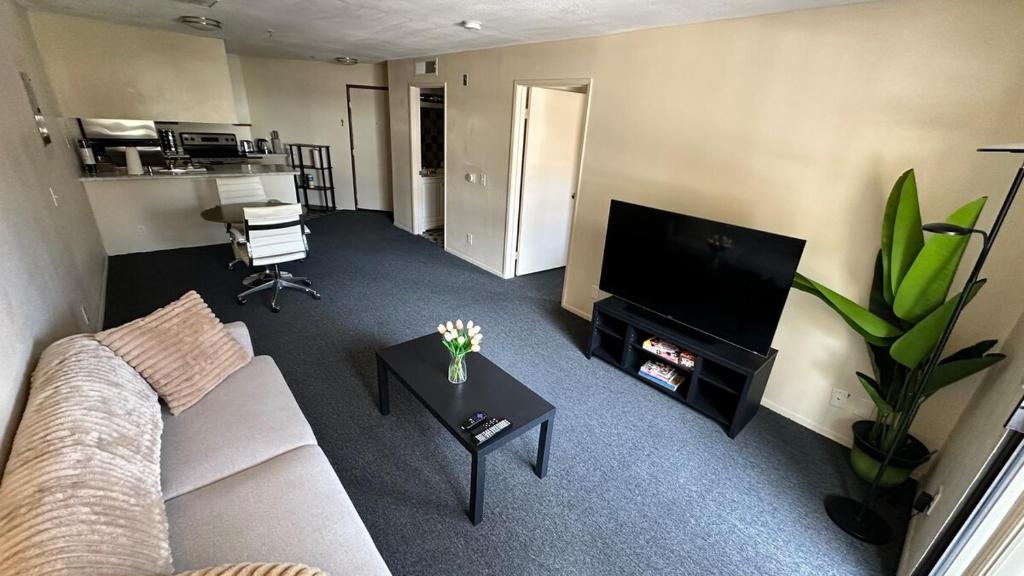 a living room with a couch and a flat screen tv at Steps from UCLA Westwood 1 Bd 1Ba in Los Angeles