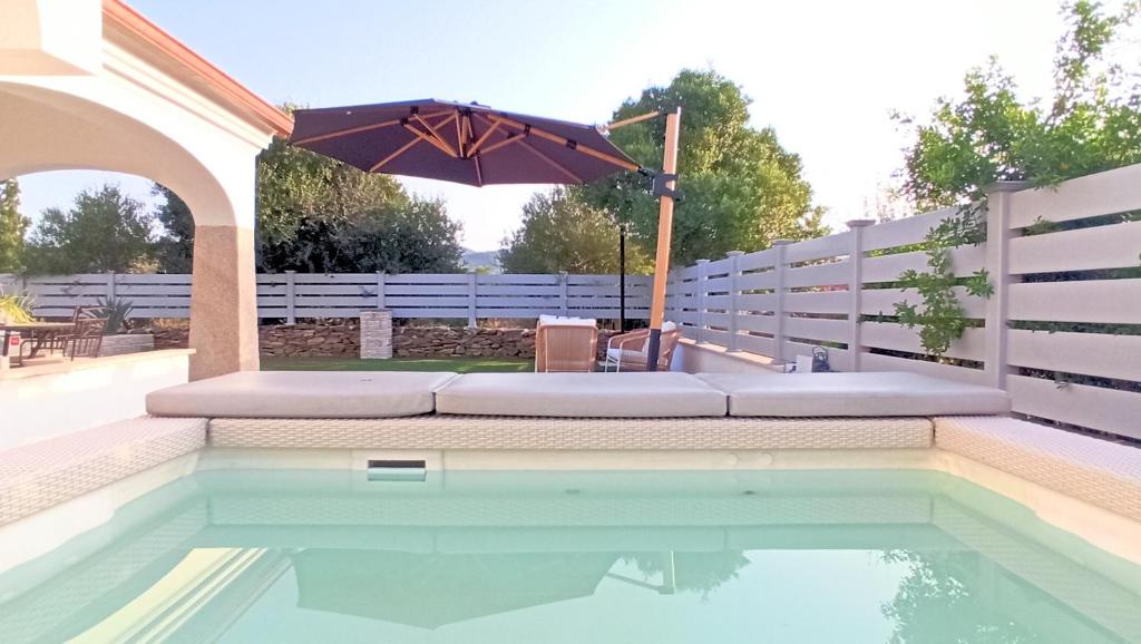 an umbrella sitting next to a swimming pool at Villa 21 in Budoni