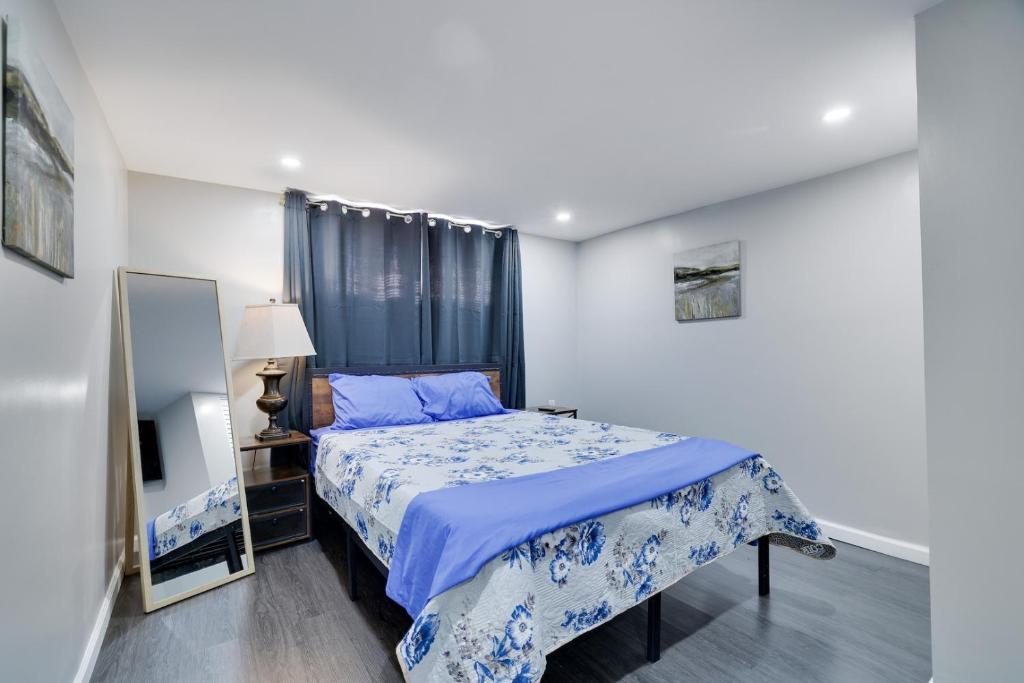 a bedroom with a bed with a blue comforter at 4BR Newark Stay w/ Parking And Fast Wi-Fi in Newark