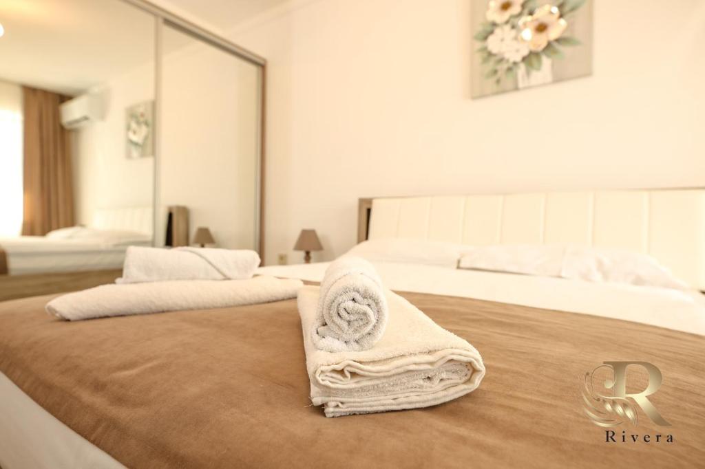 a hotel room with two beds with towels on the bed at Apartments Rivera in Dobrich
