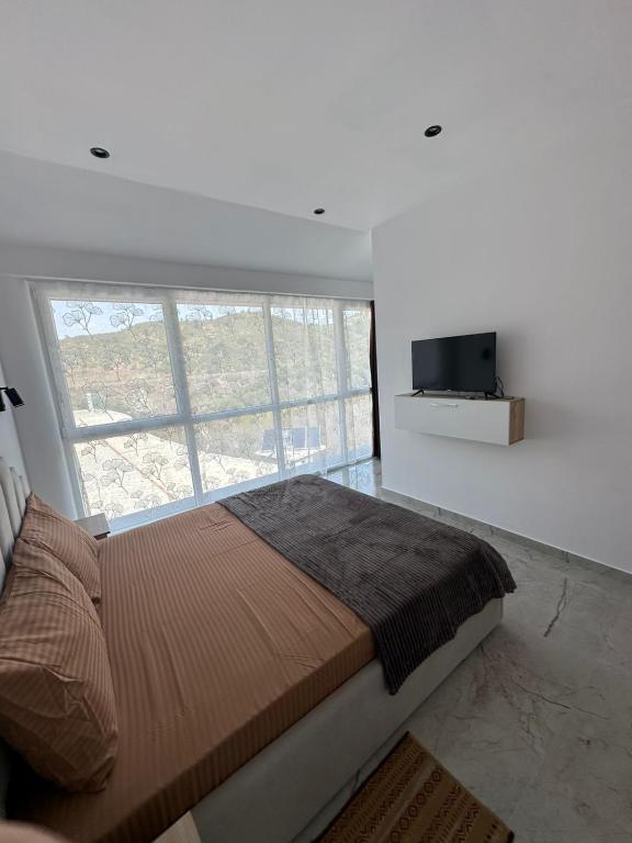 a bedroom with a bed and a large window at Qyteza guest house in Shkodër