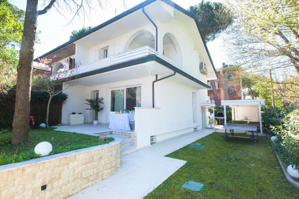 a large white house with a garden and a yard at Villa Irene in Cervia