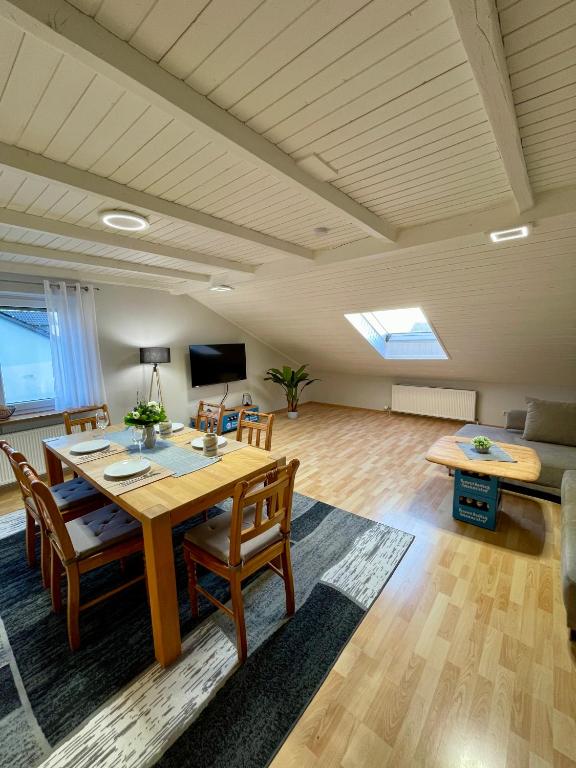 a large living room with a wooden table and chairs at FeWo Taube in Schammels dorf am Brauereienweg Platz für 7 Personen in Litzendorf
