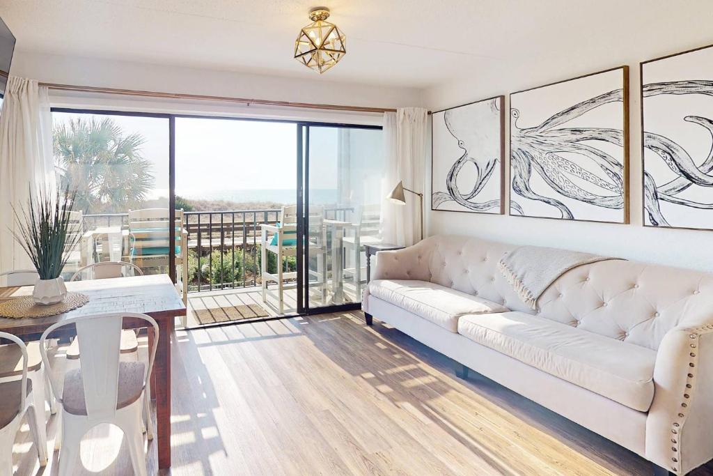 a living room with a white couch and a table at La Mare Vita in Carolina Beach