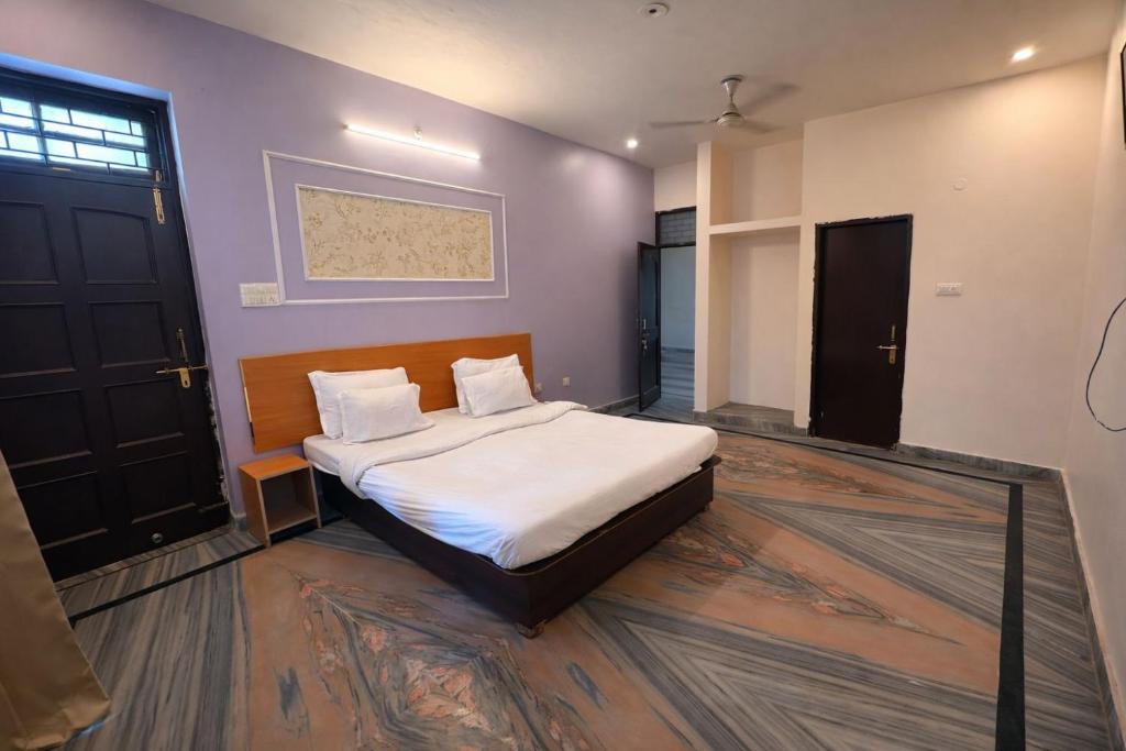 a bedroom with a bed with white sheets and pillows at Heritage Inn Gomti Nagar in Lucknow