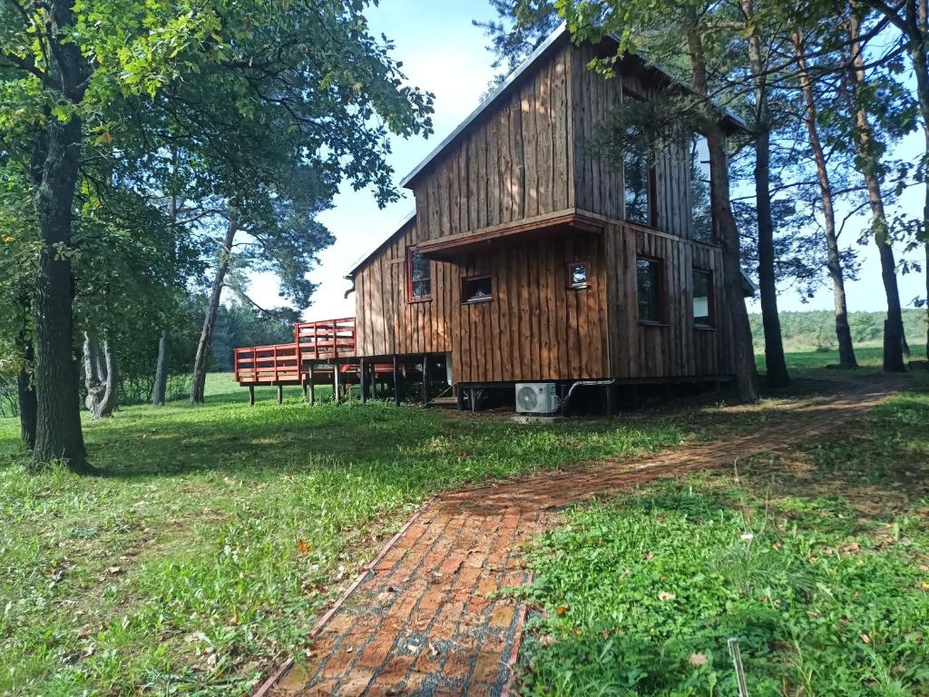 a wooden house with a bench in a field at ZegZug apartman in Pankasz