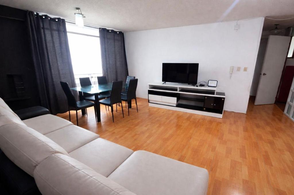 a living room with a couch and a table with chairs at Smart San Miguel in Lima
