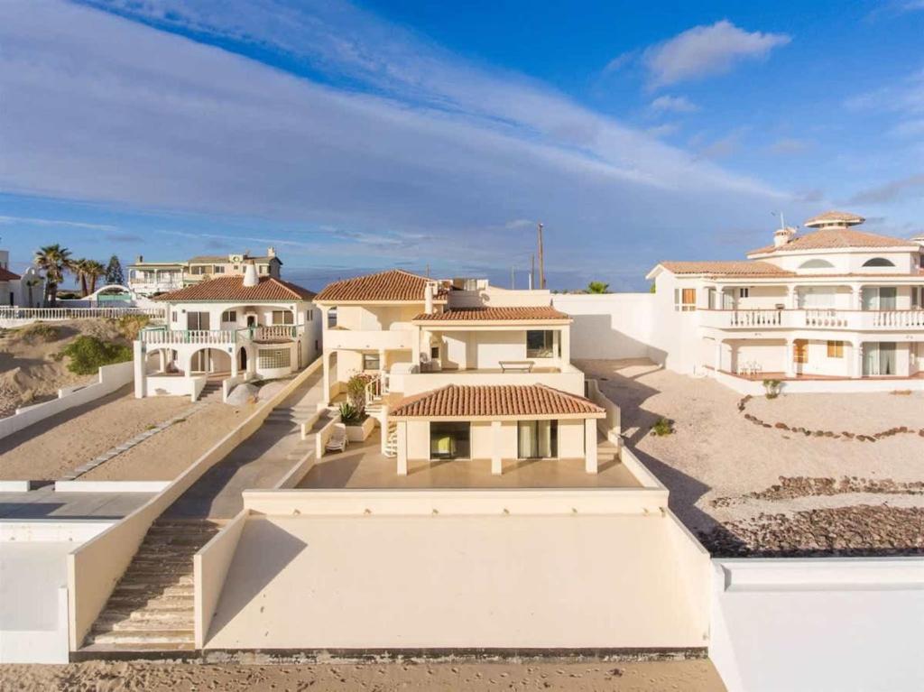 a large white house with white walls and stairs at Beautiful Huge Beachfront Home Serenity Beach in Puerto Peñasco