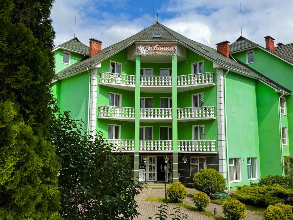 a large green building with a balcony at Квітка Закарпаття in Polyana