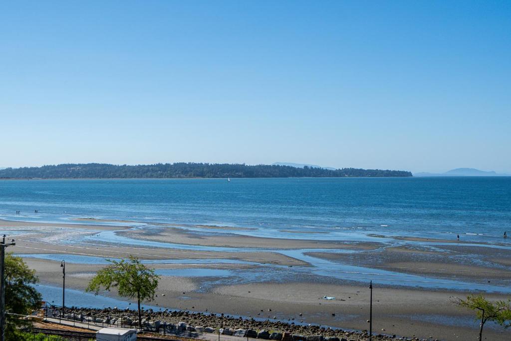 a beach with a large body of water at Oceanfront - Steps to Pier & Beach - Free Onsite Parking in White Rock