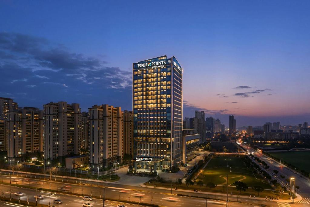 a tall building with a sign on it in a city at Four Points by Sheraton Hefei, Qirui in Hefei