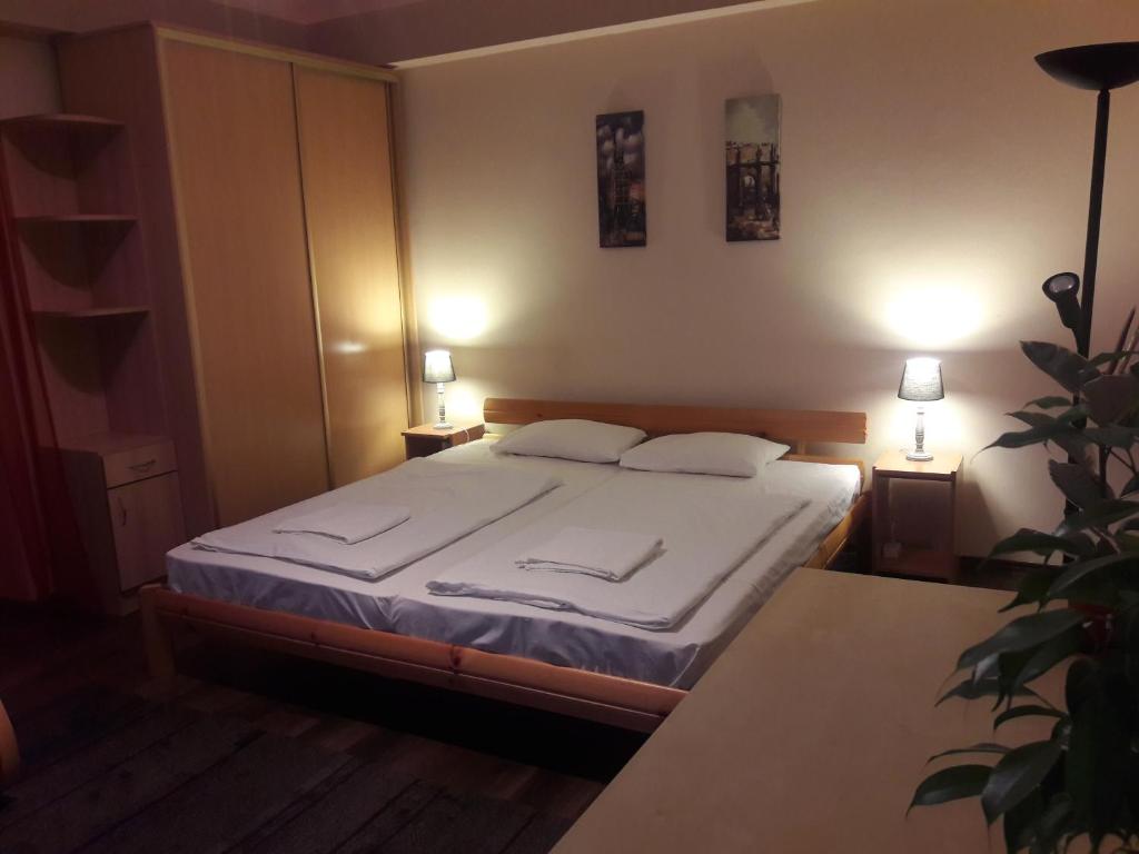 ein Schlafzimmer mit einem Bett mit zwei Kissen darauf in der Unterkunft Home Apartman in Debrecen