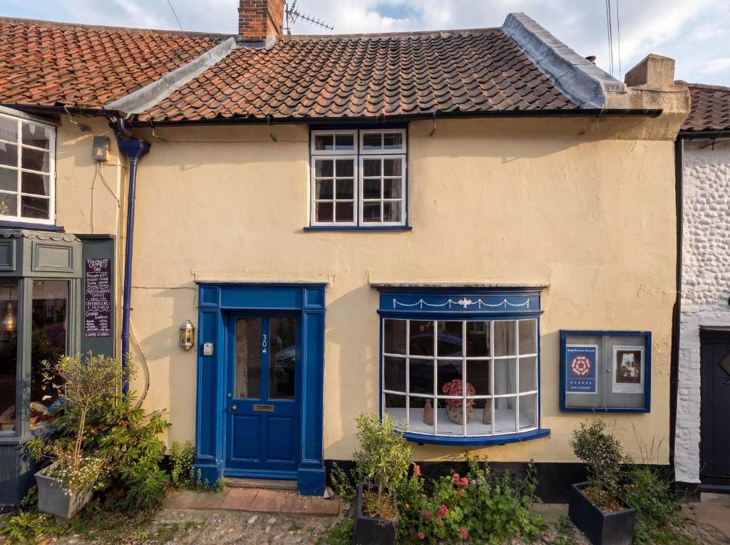 an old house with blue doors and windows at The Bittern in Holt