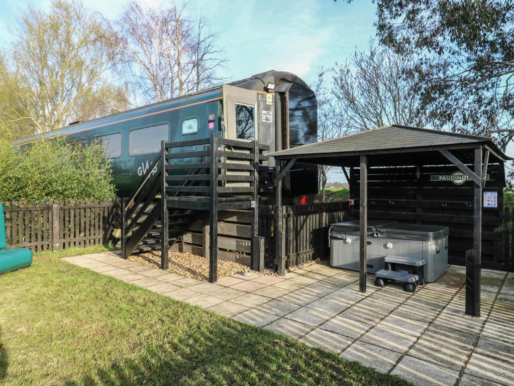 a train is parked next to a building with a tent at The Carriage Ely Paddington in Ely