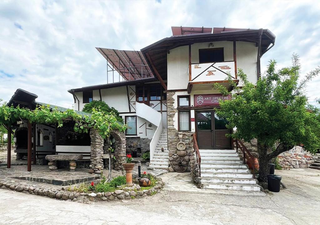 a large house with a staircase in front of it at Арт Спектър Камп in Bratsigovo