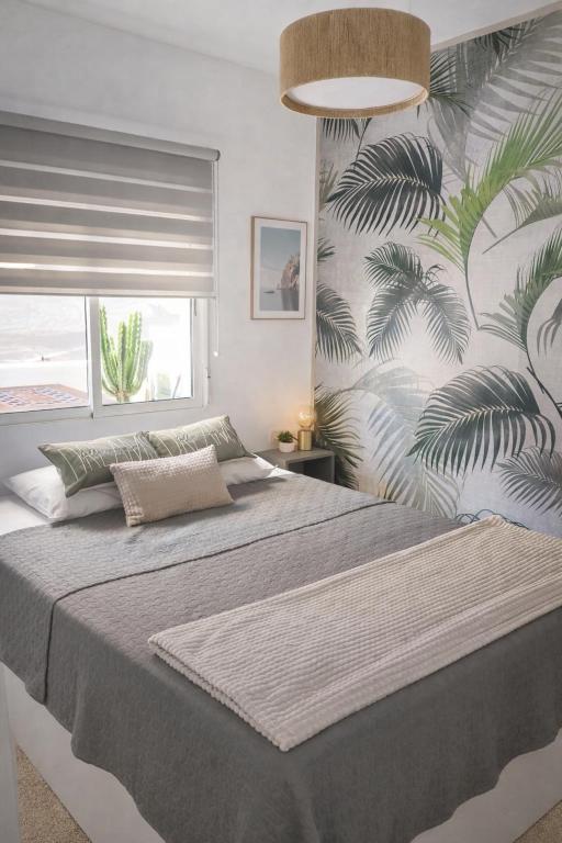 a bedroom with a large bed with a tropical wallpaper at Oasis Las Eras, Tenerife in Las Eras