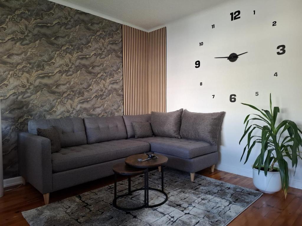 a living room with a couch and a clock on the wall at Ferienwohung Else Sankt Wendel in Sankt Wendel