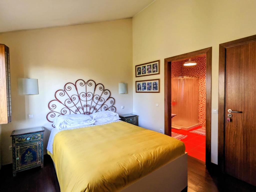 a bedroom with a large bed and a bathroom at Casa de Maria in Cotovia