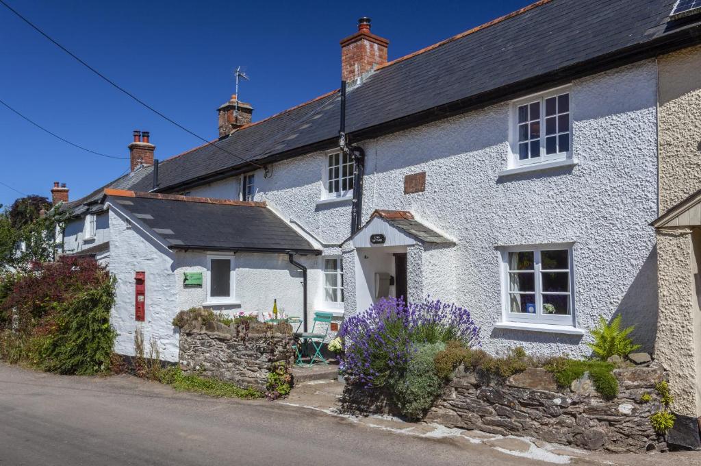 a row of white houses on the side of a street at Syms Cottage Cutcombe in Cutcombe
