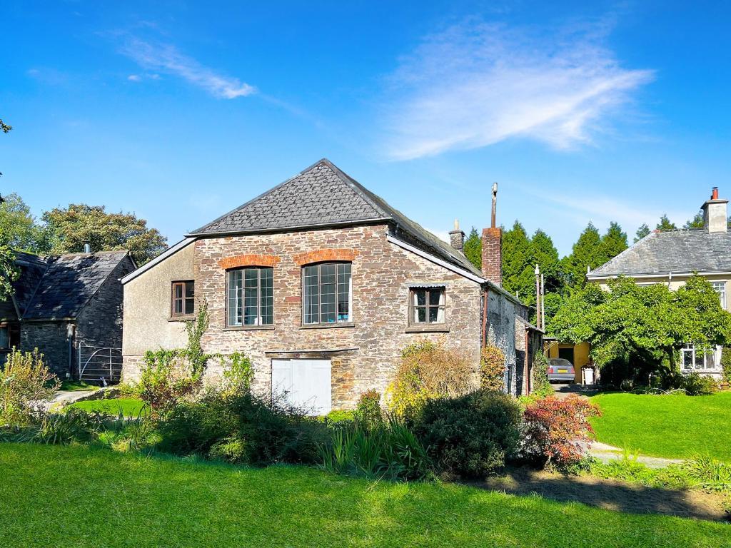 an old brick house in a yard at Barn Cottage Brayford in Charles