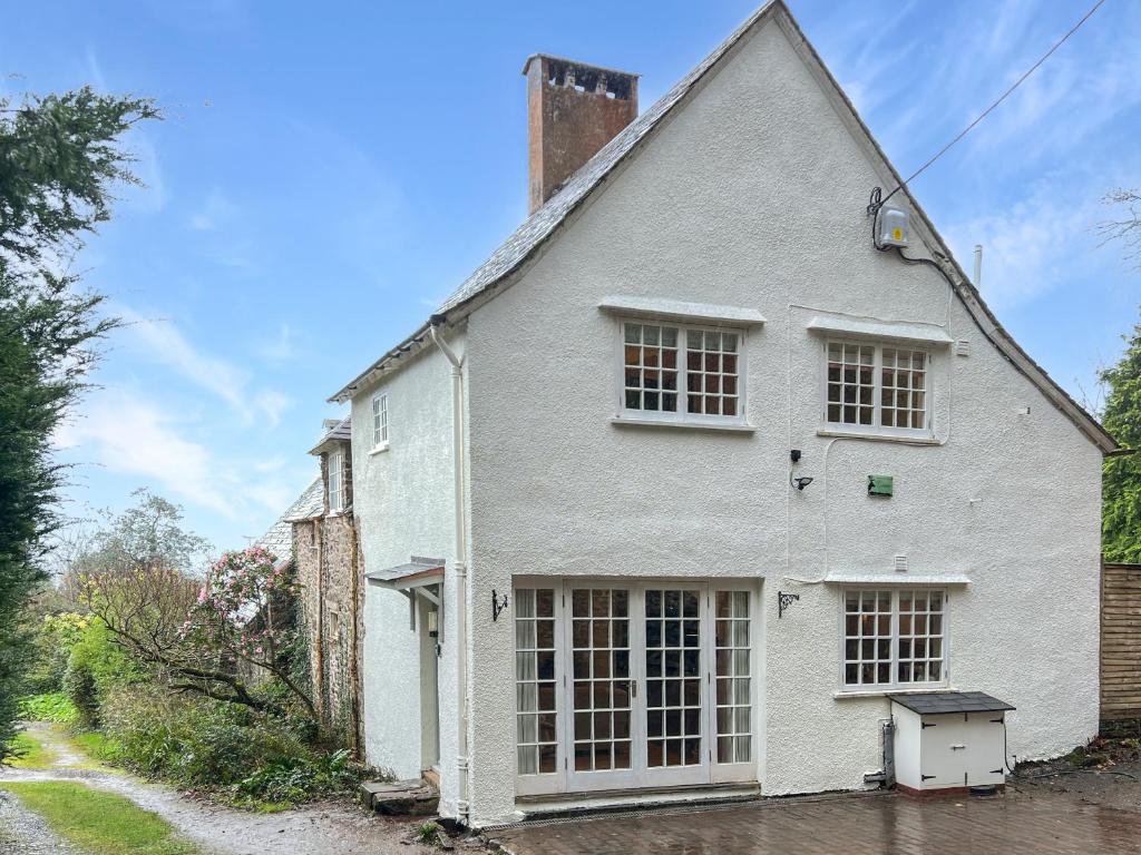 a white house with a large window at Worthy Cottage Porlock Weir in Porlock