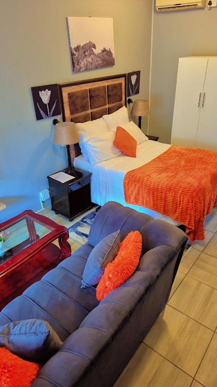 a bedroom with two beds and a couch in it at Little Haven! in Rustenburg