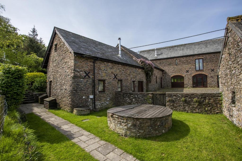 an old stone building with a bench in the yard at Yenworthy Mill Countisbury in Countisbury