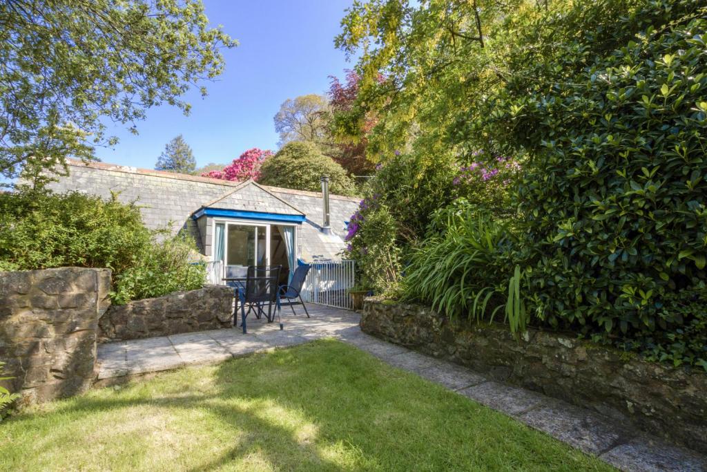 a garden with a table and chairs in front of a house at Little Hanger Porlock in Porlock