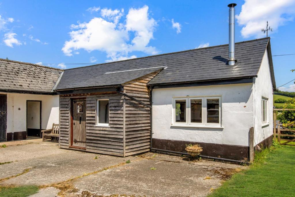 a small white house with a yard at Linhay Cottage Withypool in Withypool