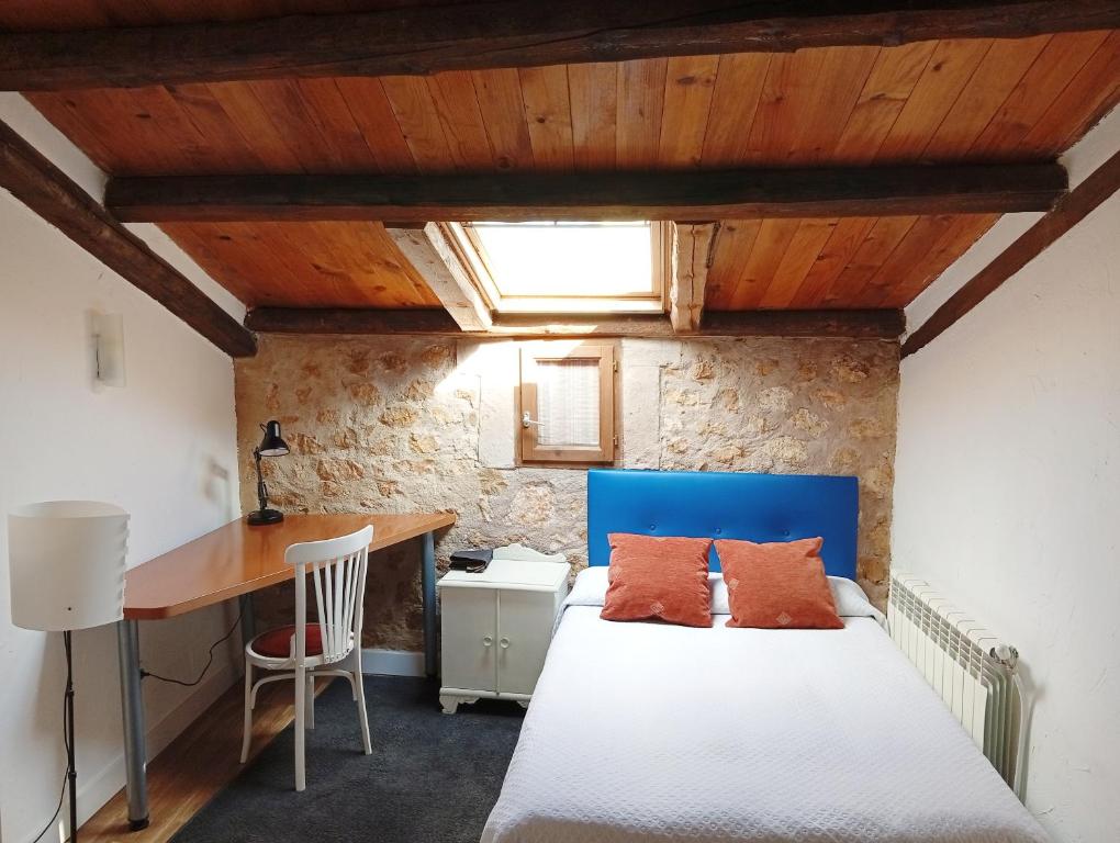 a bedroom with a blue bed and a desk at El rincón de Atenea Tu casa cerca de Guadalajara in Aldeanueva de Guadalajara