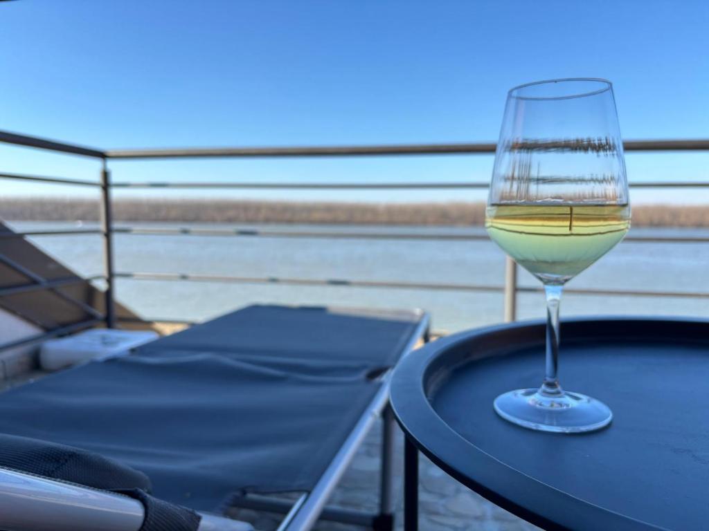 a glass of wine sitting on top of a table at Blue River, sojenica na Dunavu in Belgrade