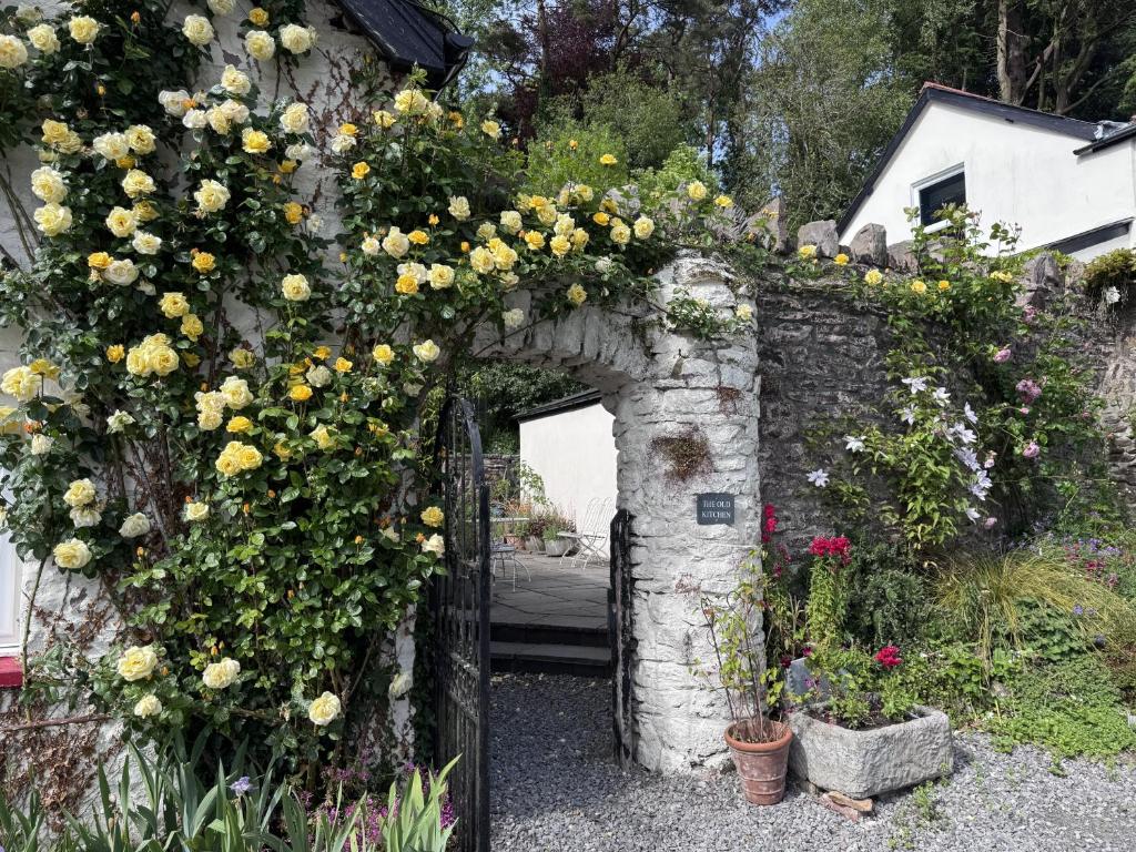 an archway with flowers on a stone wall at The Old Kitchen Exford in Exford