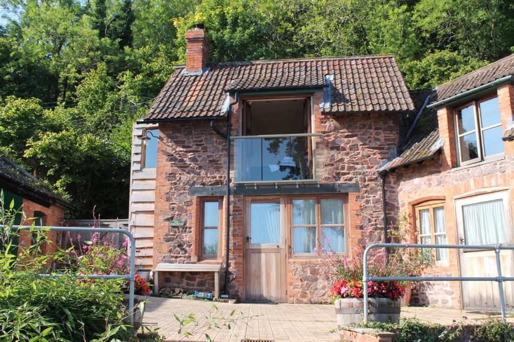 a brick house with a large glass door at The Stable Block Porlock Weir in Porlock