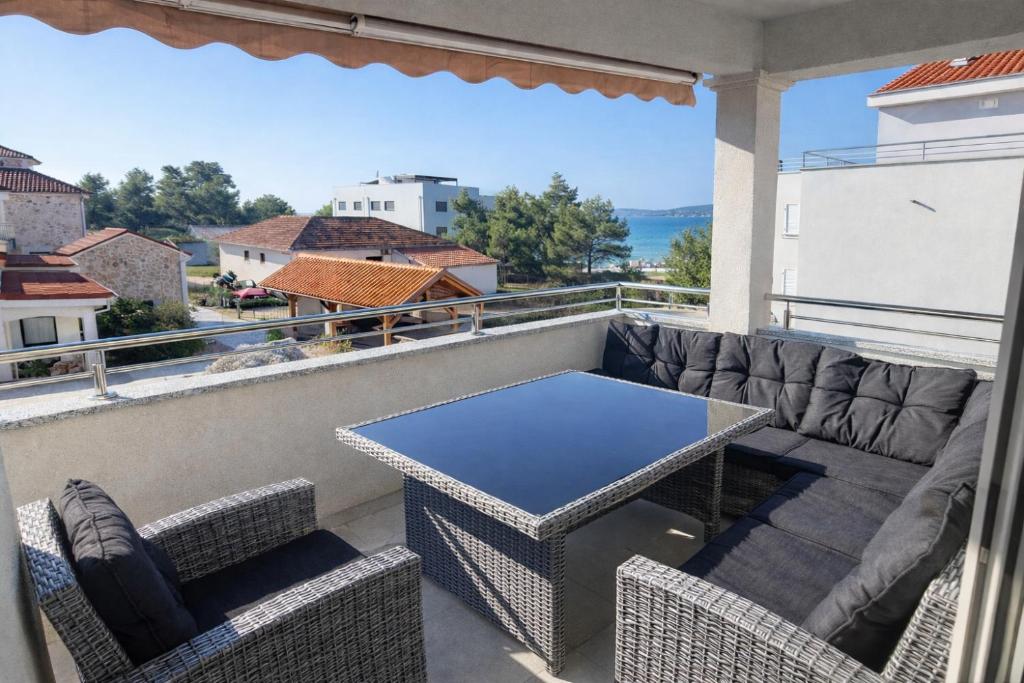 a patio with a table and chairs on a balcony at Spacious 3 Bedroom Apartment 50m from Sea 2 Bathrooms 2 Terraces Near Beach in Privlaka