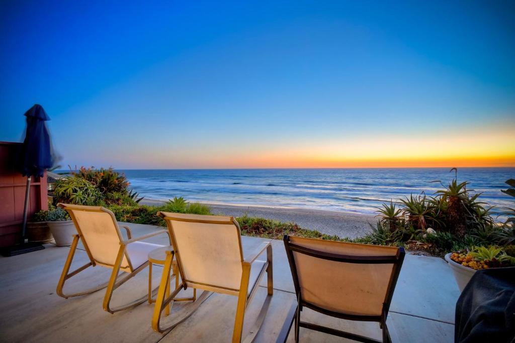 three chairs and a table with a view of the beach at Oceanfront Condo, Private Patio, Beach Access, BBQ in Carlsbad