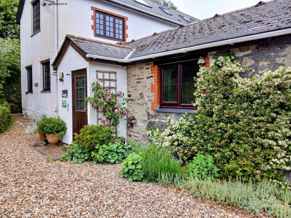 an old stone house with a garden in front of it at Sheepfold Cottage Dulverton in Dulverton