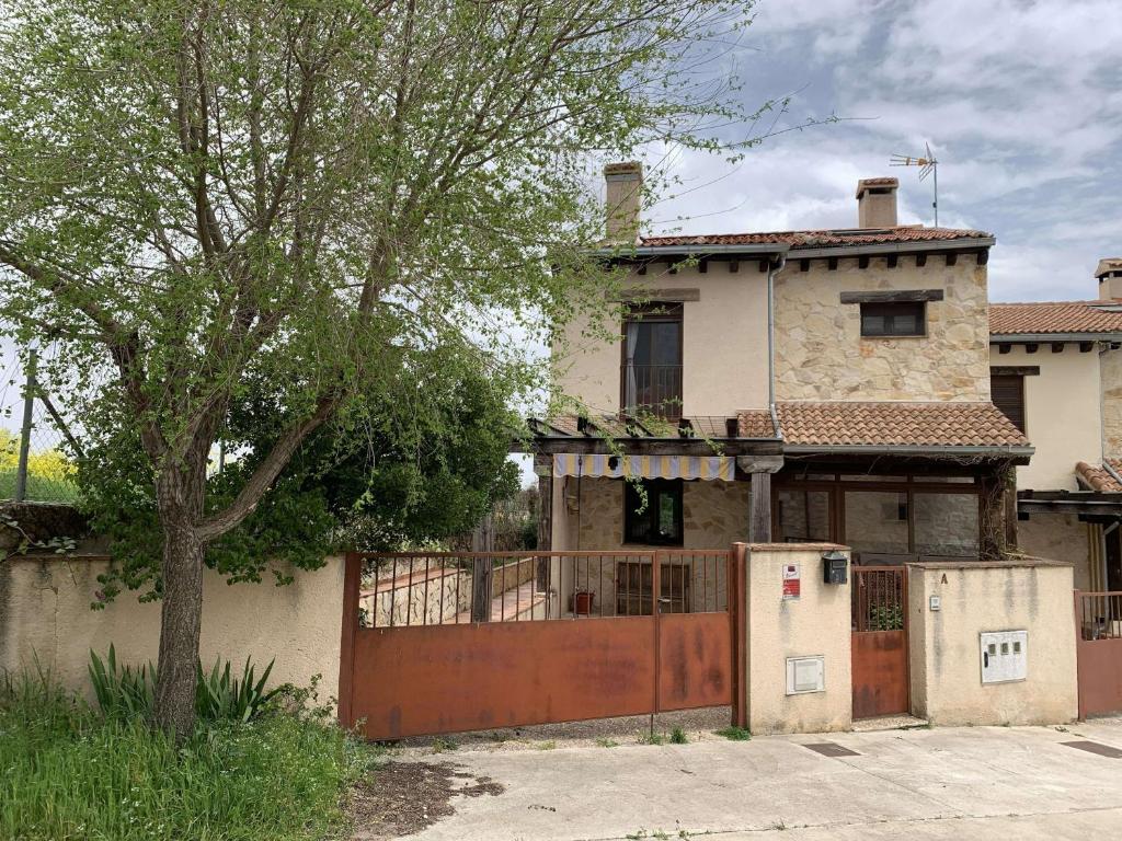 an old house with a gate and a refrigerator at El Acebo de Tanarro in Sepúlveda